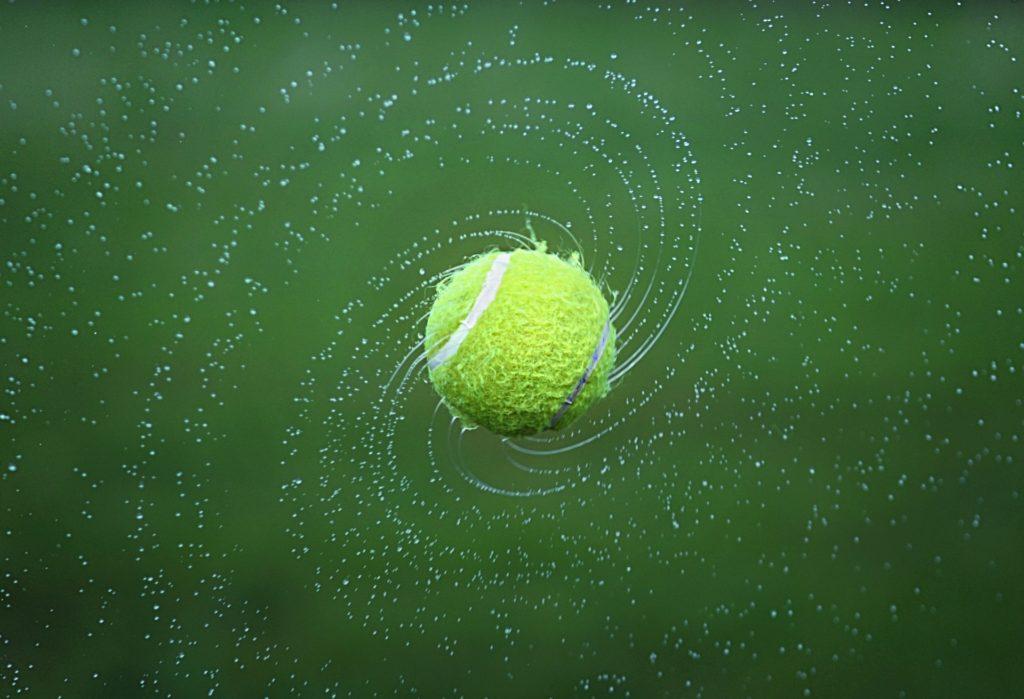 Tennis ball spinning on grass court like Wimbledon played on by Ons Jabeur in the final