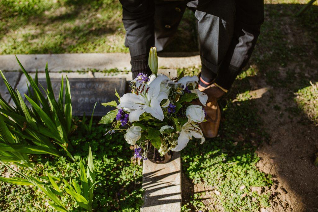 Image of flowers being laid at a grave to represent the death of Michael Parkinson